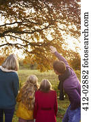 Family admiring autumn leaves in tree