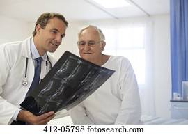 Doctor and patient examining x-rays in hospital room