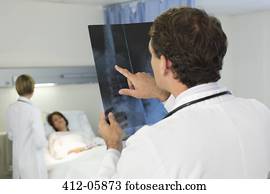 Doctor examining x-rays in hospital room