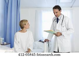 Doctor talking with patient in hospital room Doctor talking with patient in hospital room