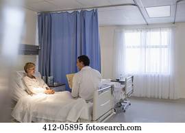 Doctor talking with patient in hospital room