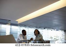 Businessman and businesswoman discussing paperwork