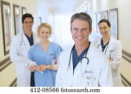 Portrait of smiling doctors and nurse in hospital corridor