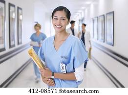 Portrait of smiling nurse in hospital corridor