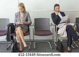 mulheres negócios, sentando, em, área espera