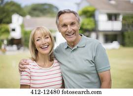 Smiling senior couple hugging outdoors