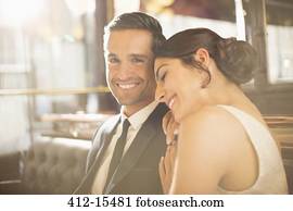 Well-dressed couple hugging in restaurant