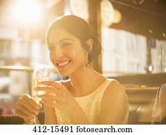Well-dressed woman drinking champagne in restaurant