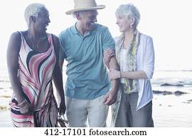 Senior friends walking on beach