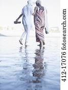Women walking barefoot on beach