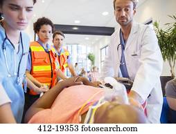 Doctor, nurses and paramedics examining patient in hospital