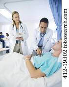 Doctors examining patient in hospital room
