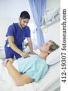 Nurse examining patient in hospital room
