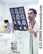 Doctor reviewing MRI scans in hospital room Doctor reviewing MRI scans in hospital room