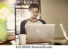 Casual businessman working at laptop