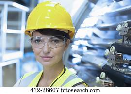 Close up portrait female confident worker in hard-hat and protective eyewear