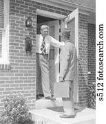 1950s Salesman At Door Talking To Housewife Stock Photo S6857