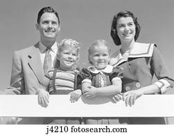 1950s Family Of Four Behind Picket Fence In Backyard Smiling At