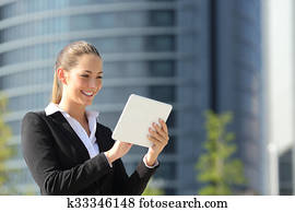 Business woman using a tablet in the street