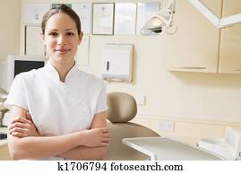 Dental assistant in exam room smiling Dental assistant in exam room smiling