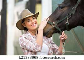 happy cowgirl and her horse in stable happy cowgirl and her horse in stable