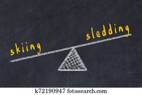 Chalk board sketch of scales. Concept of balance between skiing and sledding Chalk board sketch of scales. Concept of balance between skiing and sledding