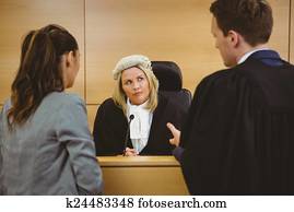 Judge wearing dress and wig listening lawyers Judge wearing dress and wig listening lawyers