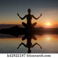 Silhouette of a young meditating lady