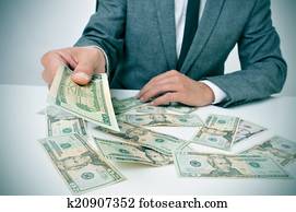 man in suit giving dollar bills