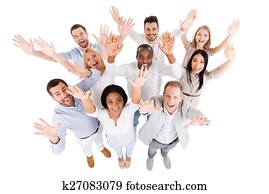 Successful business team. Top view of positive diverse group of people in smart casual wear looking at camera and stretching out their hands while standing close to each other