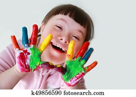 Cute little down syndrome girl with painted hands. Cute little down syndrome girl with painted hands.