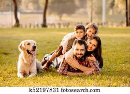 family lying in pile on grass