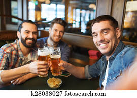 friends taking selfie and drinking beer at bar friends taking selfie and drinking beer at bar