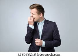 Caucasian young man in suit biting nails feeling nervous. Caucasian young man in suit biting nails feeling nervous.