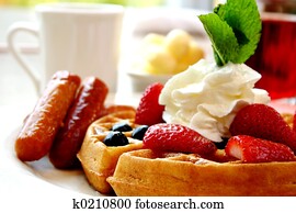 Blueberry waffles with strawberries and sausages Blueberry waffles with strawberries and sausages