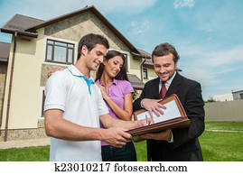 Young man signing renting contract with real estate agent. agent holding documents to sign agreement for house sale Young man signing renting contract with real estate agent. agent holding documents to sign agreement for house sale