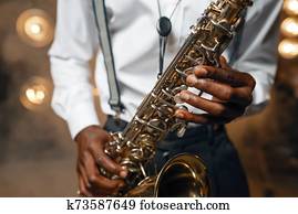 Male jazz performer plays the saxophone on stage Male jazz performer plays the saxophone on stage