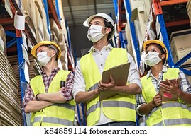 Interracial warehouse worker team with face mask