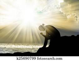 Woman praying to god at sunset