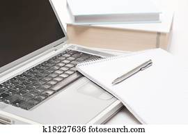 Office desk laptop with notepad and pen