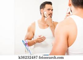 Man putting shaving cream on his face Man putting shaving cream on his face