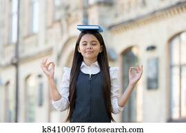 Calm the mind. Little child do meditation outdoors. Small girl do mudra hands holding book on head. Meditation for mental balance. Meditation course for beginner. School and education. Best therapy Calm the mind. Little child do meditation outdoors. Small girl do mudra hands holding book on head. Meditation for mental balance. Meditation course for beginner. School and education. Best therapy