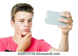 Teen boy taking self portrait with smart phone.