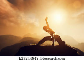 Asian man, fighter practices martial arts in high mountains at sunset.