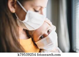 Mother and child with face masks indoors at home, Corona virus and quarantine concept. Mother and child with face masks indoors at home, Corona virus and quarantine concept.