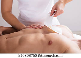 Woman Waxing Man's Chest With Wax Strip Woman Waxing Man's Chest With Wax Strip