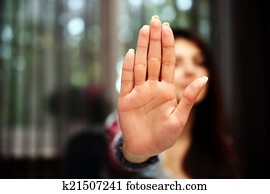 Woman with her hand extended signaling to stop (only her hand is in focus)