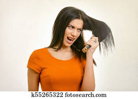 Tangled messy hairstyle problem. Woman brushing her damaged hair