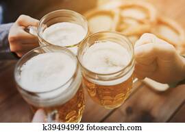 close up of hands with beer mugs at bar or pub close up of hands with beer mugs at bar or pub
