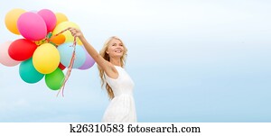 smiling woman with colorful balloons outside